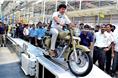 Siddhartha Lal rolls the first production motorcycle off the assembly line. 
